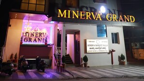 En bygning med skiltet "MINERVA GRAND", der angiver at det er et hotel.