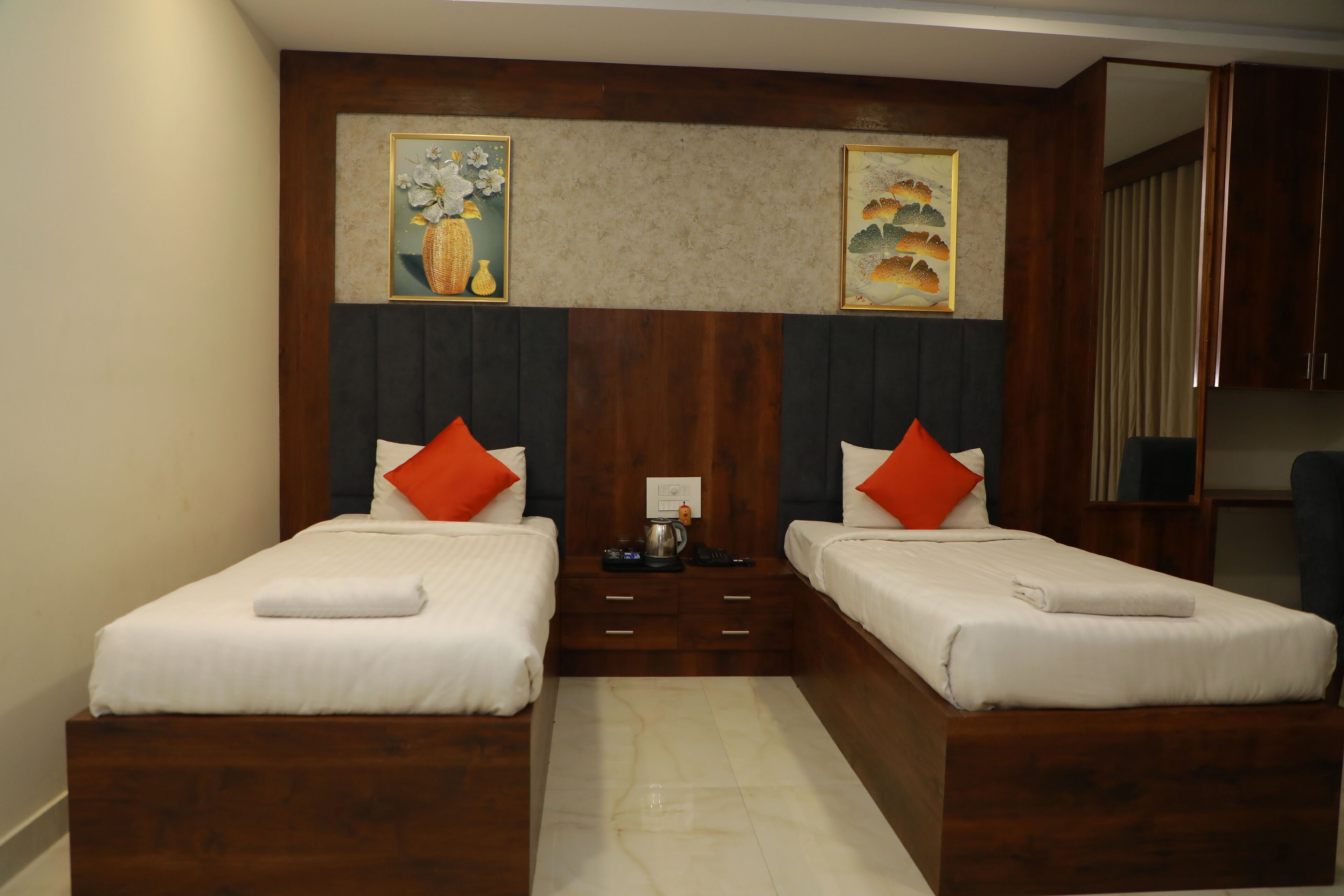 A double bed room with two single beds, a nightstand with a lamp, and artwork on the wall.