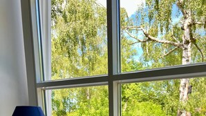 A window with a view of a green garden and a white sign that reads "Relax". - Bloom | small, cozy apartment with lake access to Wörthsee & WLAN (Wörthsee)