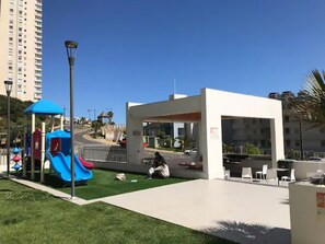 Relax in a serene outdoor space with a play area, seating, and a covered pavilion.