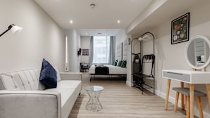 Um quarto moderno com uma cama, mesa de cabeceira e escrivaninha com cadeira.