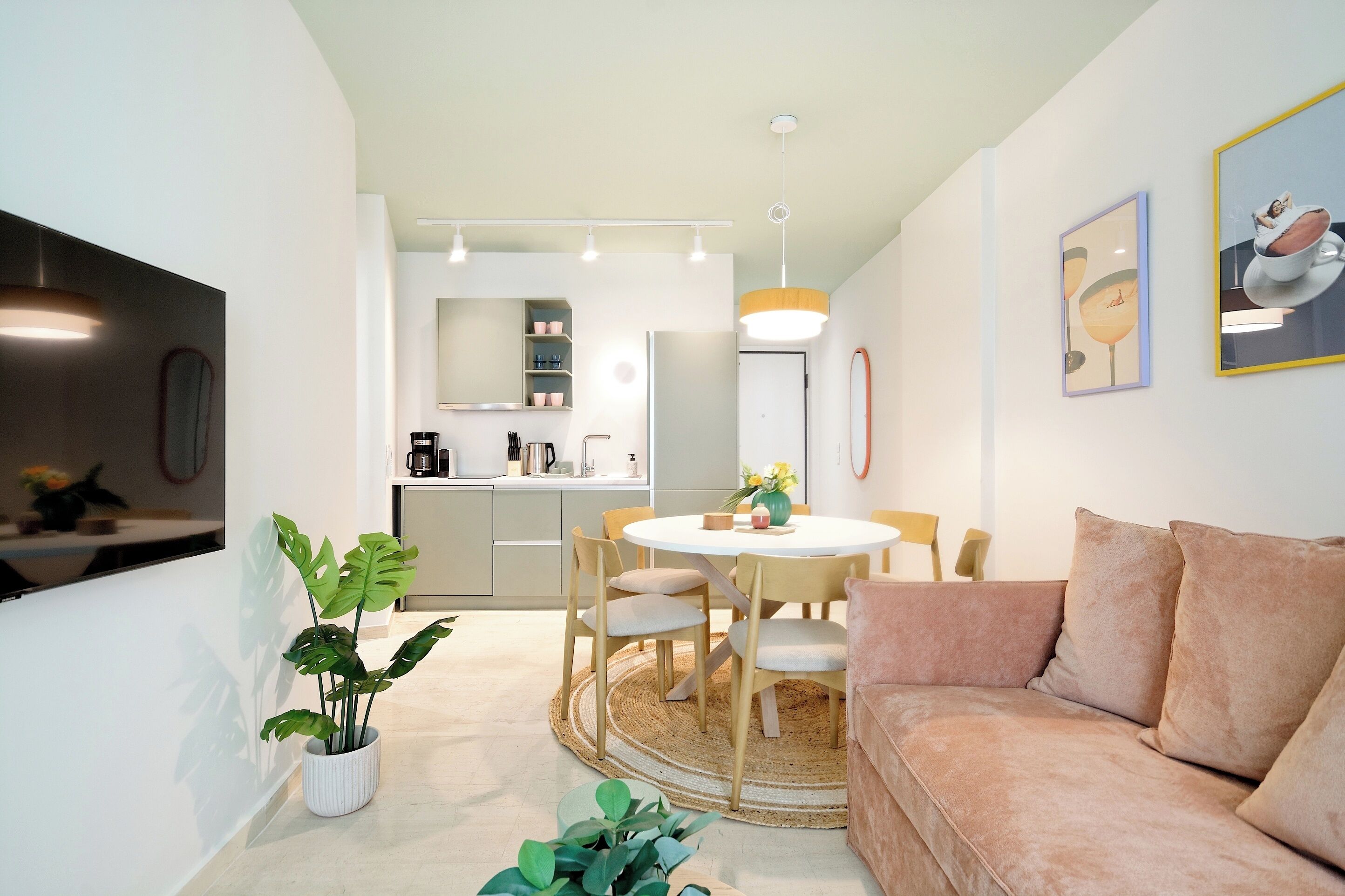 A modern living room with a round table, beige sofa, and a potted plant.