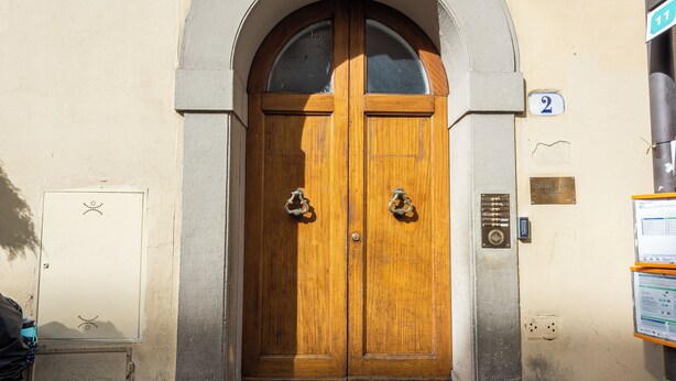 A double wooden door with a glass panel above, flanked by stone pillars, and a number plaque indicating room 2. - Sauro River View by MMega (Florence)