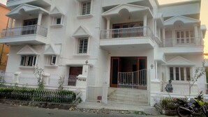 A multi-story building with balconies, a gated entrance, and a staircase leading to the main entrance. - Ashray The Living Entity  (Bidhannagar)