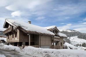 A wooden lodge with a balcony and a stone foundation, surrounded by snow-covered mountains. - Wifi, 150m from resort center, 2nd floor, sauna, balcony, parking, tv, 64m², Courchevel (Courchevel)