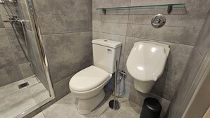 Een moderne badkamer met een douchecabine van glas, een toilet en een bidet.