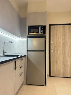 Departamento superior, balcón | Cocina privada | Refrigerador con congelador, microondas, horno y parrilla de estufa 