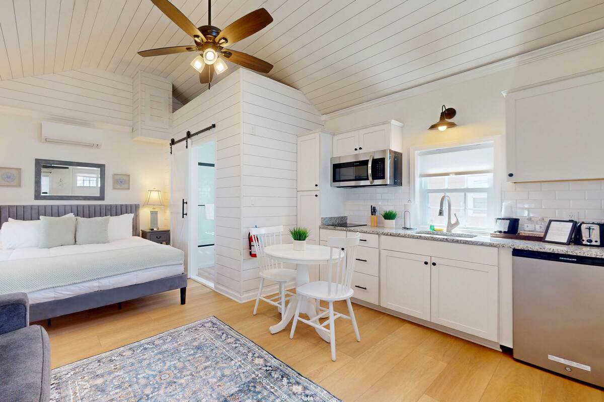 A bedroom with a bed, bedside tables, a ceiling fan, and a nightstand.