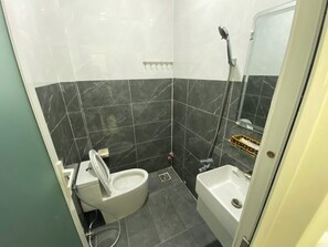 Un baño con inodoro, bidé y ducha.