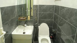Ein Badezimmer mit einem weißen Waschbecken, einer Toilette und einer Duschkabine aus Glas.