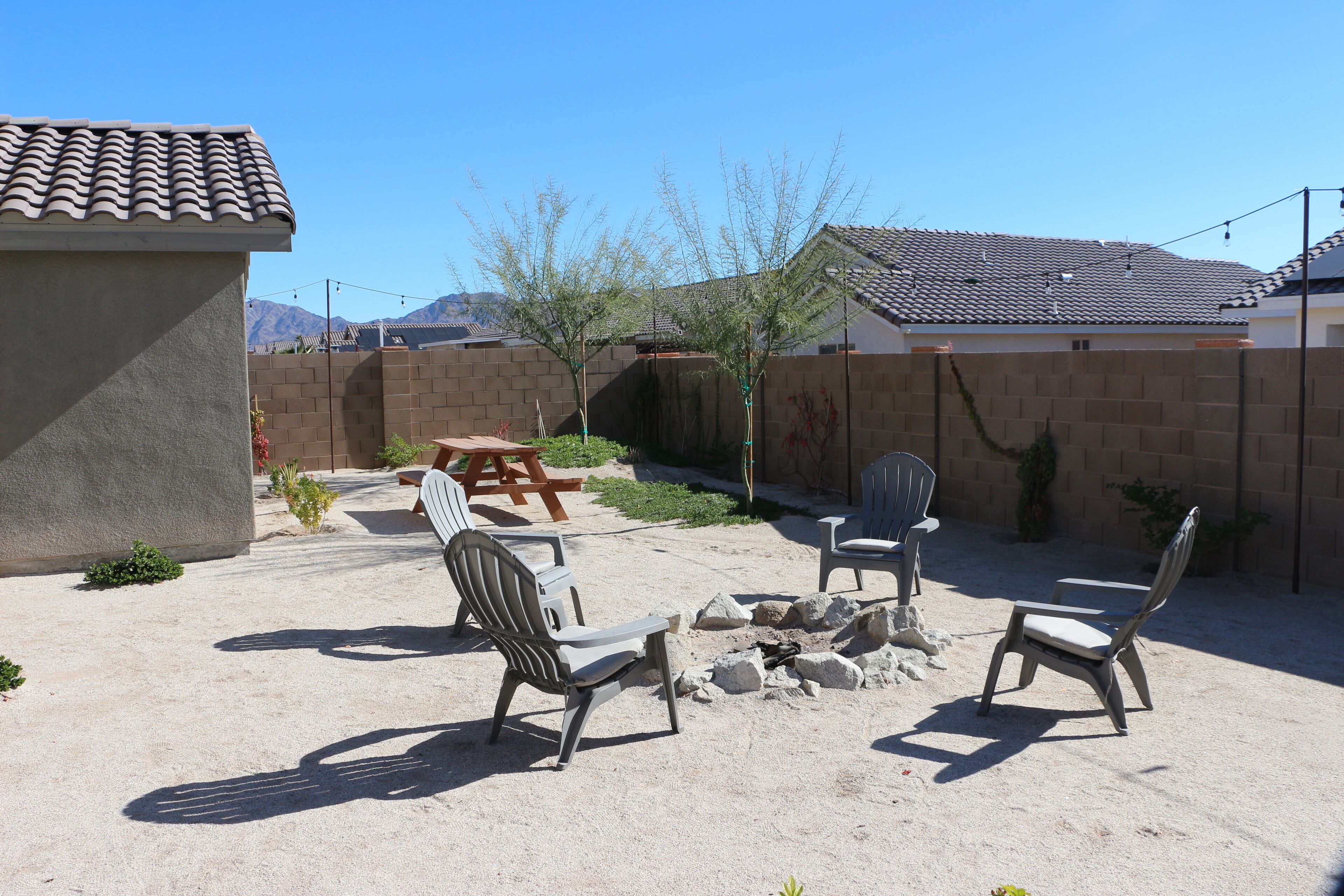 A patio area with outdoor seating, a fire pit, and a view of a mountain range.