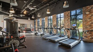 A gym with treadmills, weights, and a mirror.