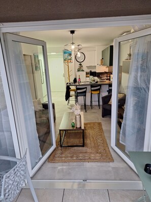 A modern living space with a dining area, kitchen, and sliding glass doors leading to a balcony. - SUPERB NEW APARTMENT in new secure residence ideally located (La Seyne-sur-Mer)
