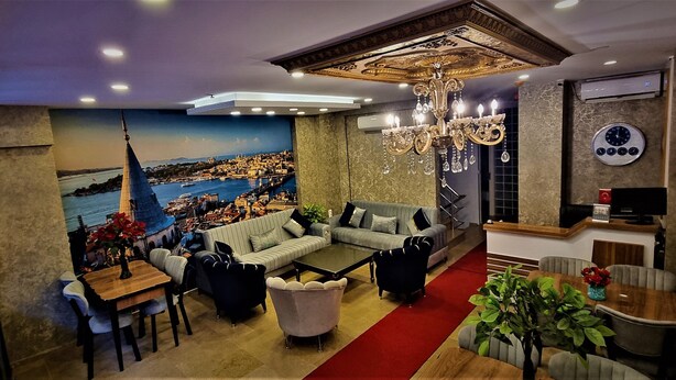 A modern living room with a cityscape mural, a chandelier, and a red carpet. - By Historyal Hotel Due (Istanbul)