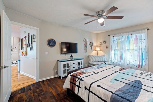 A bedroom with a bed, a ceiling fan, a TV, a nightstand, and a window with curtains. - Vintage 50's & 60's theme Country Home on Wooded Acres near Franklin, Tennessee (Primm Springs)