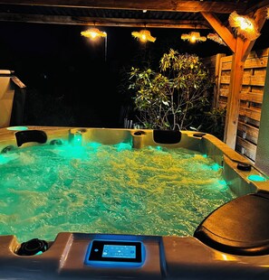 A hot tub with a control panel displaying 37.5°C, surrounded by wooden structures and plants. - 
Mini-Villa 75m² piscine jacuzzi salle de sport privatisés à 800m des commerces (La Baule-Escoublac)