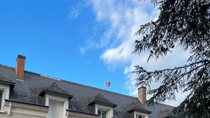 Ein Innenhof mit einem Esstisch, umgeben von weißen Stühlen.