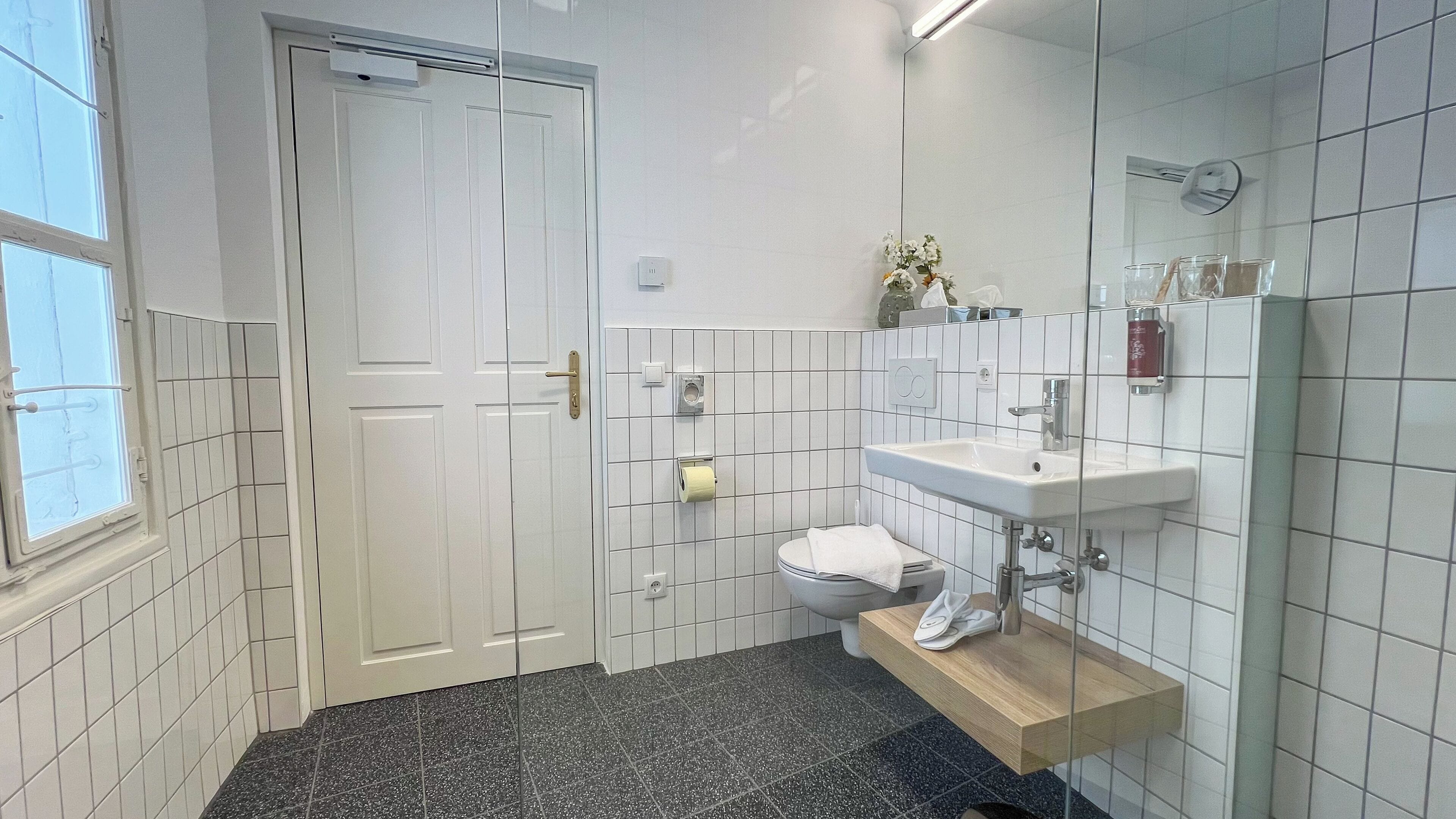 Moderni kylpyhuone, jossa on wc, pesuallas ja peili.