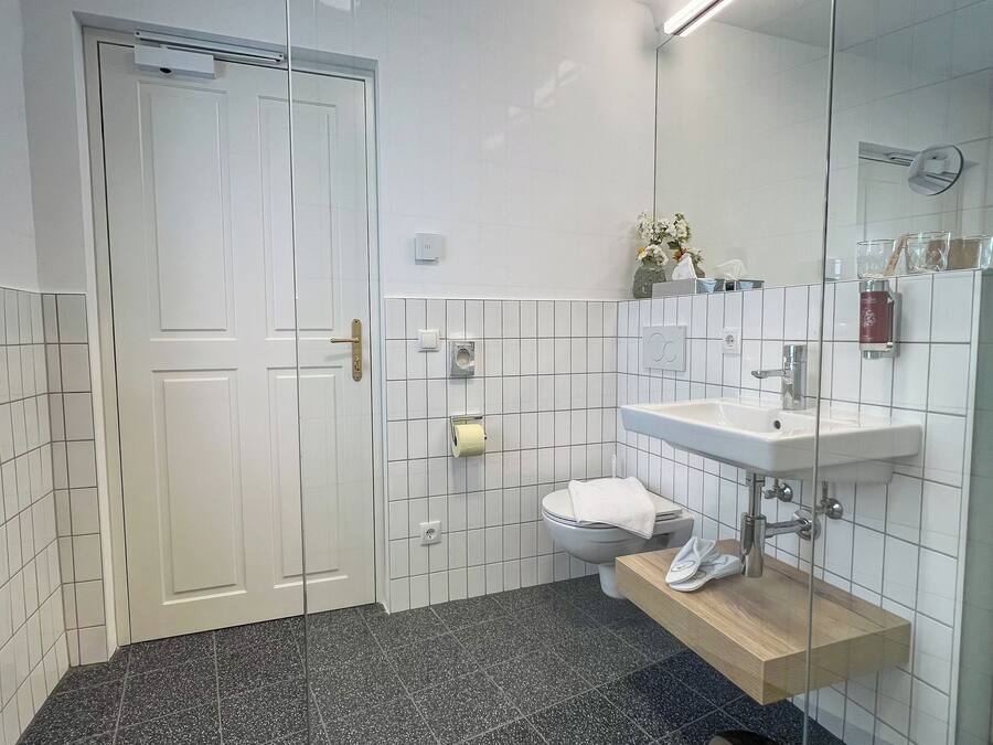 A modern bathroom with a toilet, sink, and mirror.