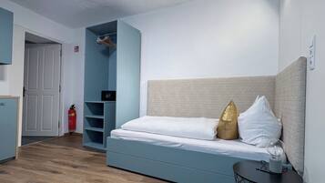 Un dormitorio moderno con cama, mesita de noche, armario y puerta.