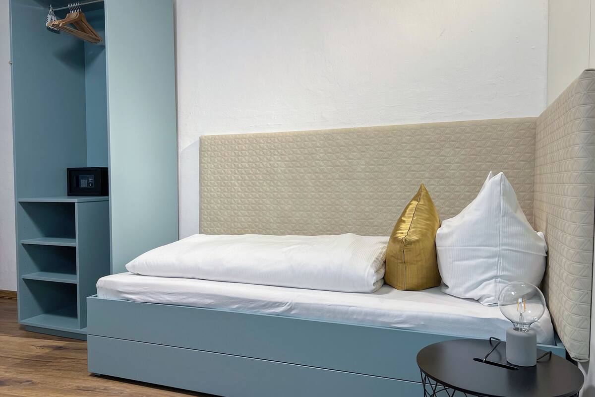 Une chambre à coucher moderne avec un lit, une table de chevet et une armoire.