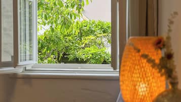 Ein Fenster mit Blick auf einen grünen Baum.