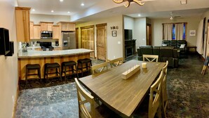 Una cocina moderna con armarios de madera, un microondas integrado y una isla grande con taburetes de bar.