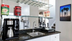 Eine moderne Küche mit Kaffeemaschine, Kaffeefiltern und einer Kaffeemühle.