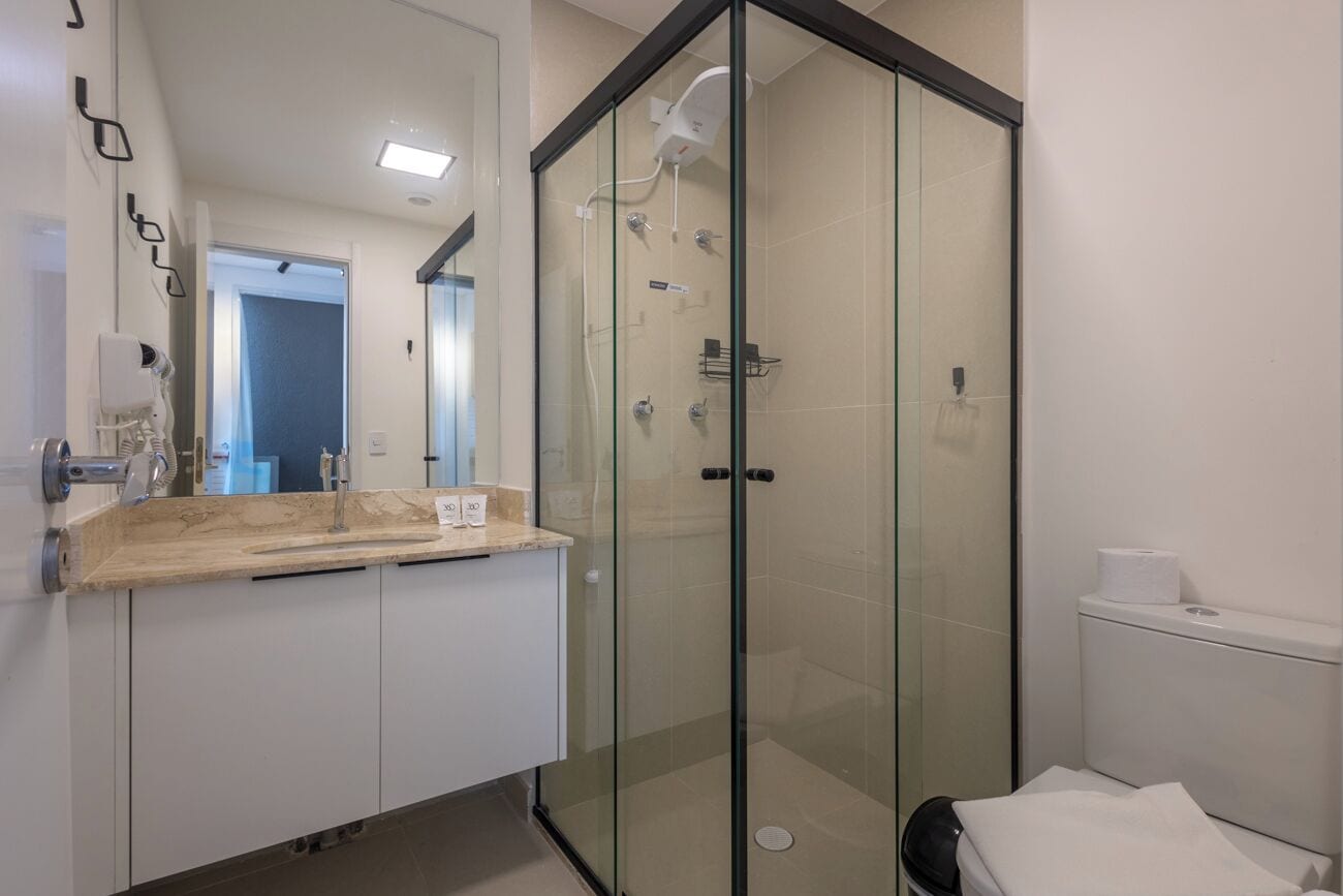 Un baño moderno con ducha de vidrio, tocador de madera y retrete.