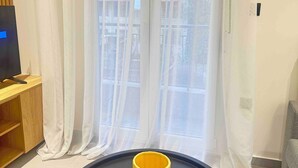 Deluxe appartement, balkon | Woonruimte | Een 40-inch flatscreentelevisie met digitale zenders