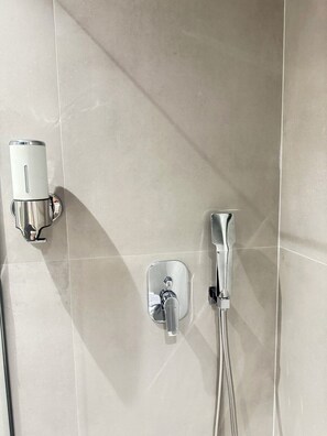 Deluxe appartement, balkon | Badkamer | Een douche, een haardroger, handdoeken, zeep