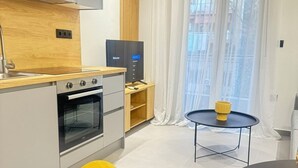 Deluxe appartement, balkon | Privékeuken | Een koffiezetapparaat/waterkoker, een koelkast met diepvriezer, een oven