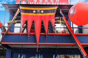Un edificio con fachada roja y azul, un letrero que dice 'VIDEELUFT' y un globo rojo.