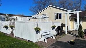 A house with a white fence, a porch, and a small garden area. - Auberge Eldo Inn (Blind River)