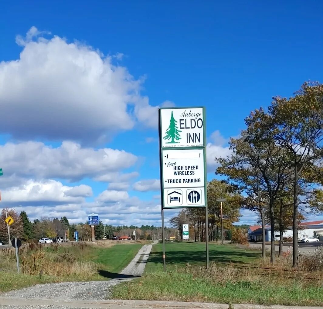 A sign for Auberge Eldo Inn highlighting amenities like free high-speed wireless, truck parking, and a bed icon.