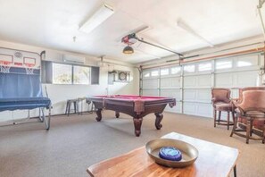 A room with a pool table, a basketball hoop, and a dining table with chairs. - Yucca Valley Oasis: Pool, Spa & Game Room Retreat (Yucca Valley)