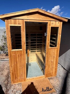 A wooden structure with a door, a window, and a small enclosed area with a bench.