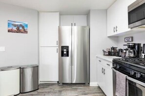 A modern kitchen with stainless steel appliances, a built-in oven, and a microwave. - Yucca Valley Oasis: Pool, Spa & Game Room Retreat (Yucca Valley)