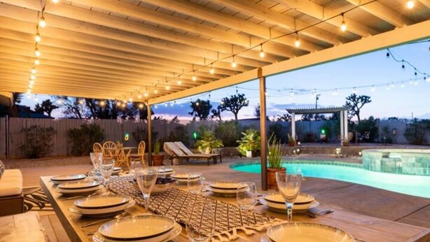 An outdoor dining area with a pool in the background. - Sun Mesa Poolside Hideaway | Spa | Game Room | NEW, Sun Mesa Poolside Hideaway | Spa | Game Room | N (Yucca Valley)