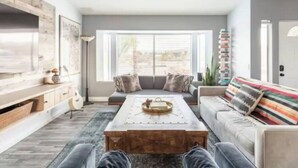A modern living room with a sofa, coffee table, and a TV. - Sun Mesa Poolside Hideaway | Spa | Game Room | NEW, Sun Mesa Poolside Hideaway | Spa | Game Room | N (Yucca Valley)