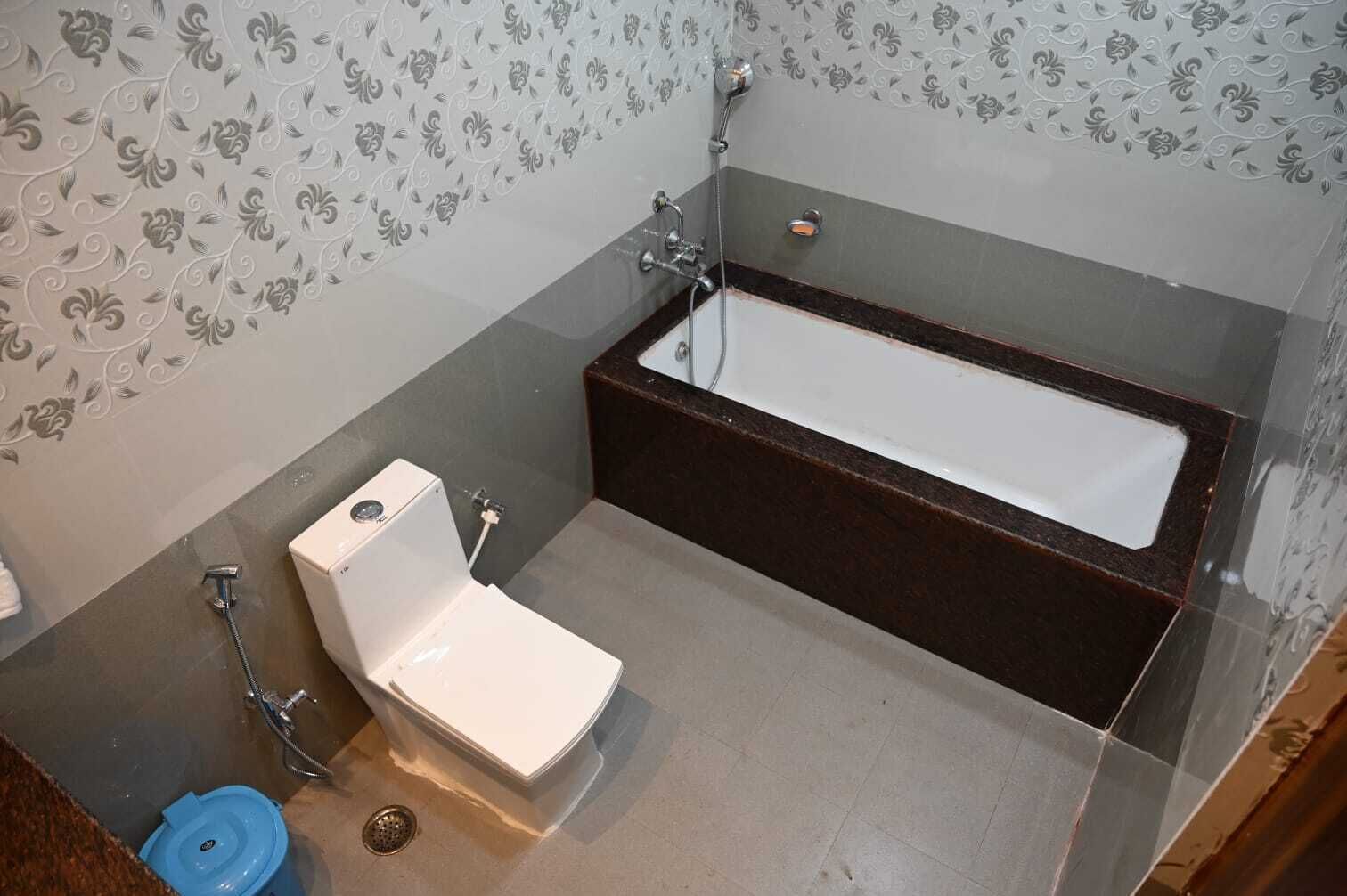 A bathroom with a bathtub, toilet, and shower.