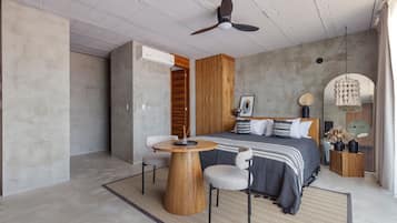 A modern bedroom with a bed, a wooden side table, a round wooden table, and a ceiling fan.