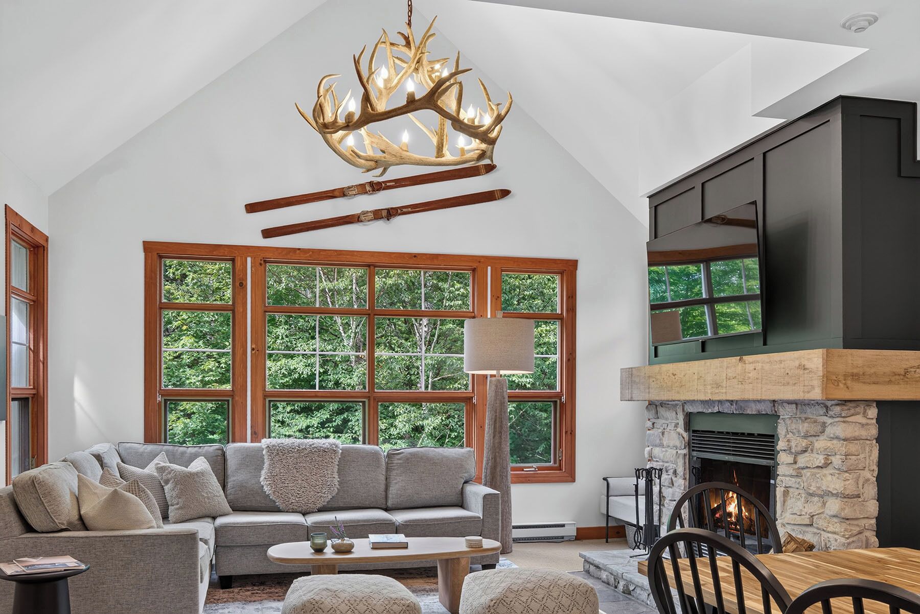 A spacious living room with a large window, a fireplace, a sofa, and a television.