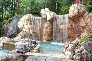 Une formation rocheuse naturelle avec une cascade et un bassin.