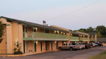 A motel with multiple balconies and a parking lot.