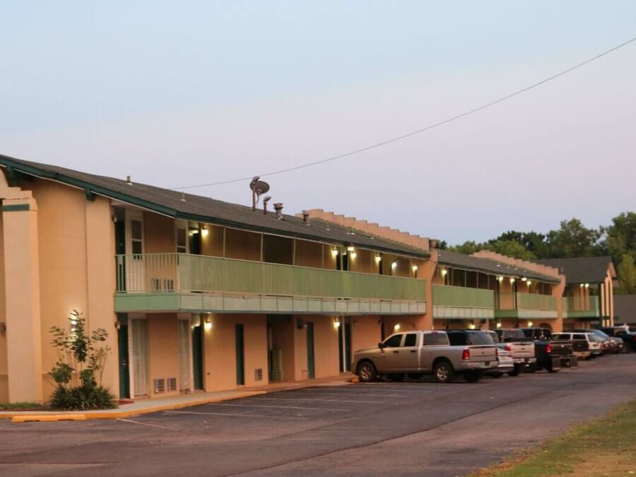 A motel with multiple balconies and a parking lot.