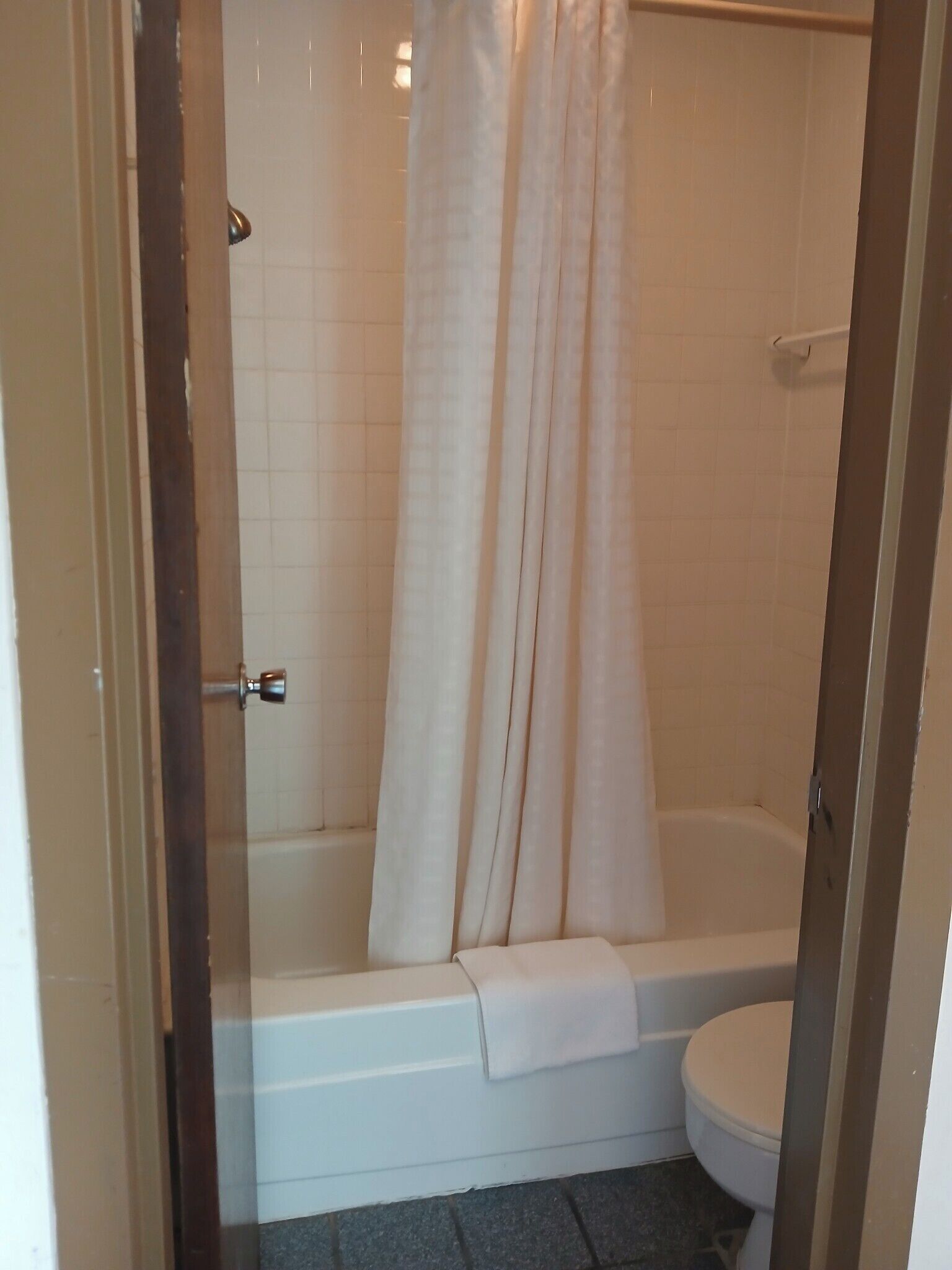 Un baño con bañera, inodoro y cortina de ducha.