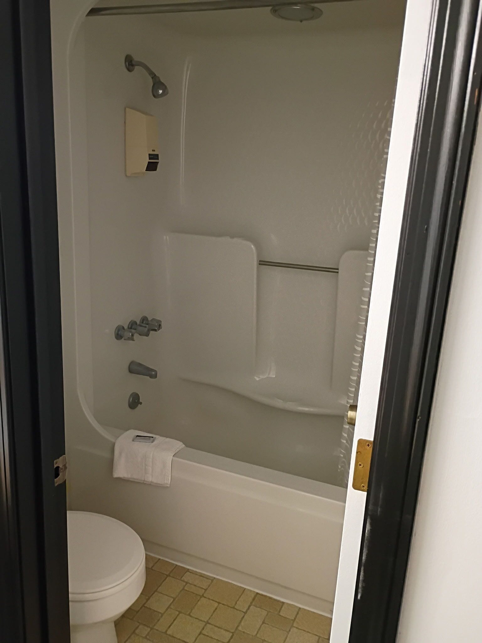 A bathroom with a bathtub, toilet, and a towel rack.