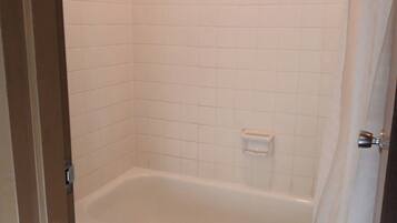A bathroom with a white toilet, a bathtub, and a shower curtain.