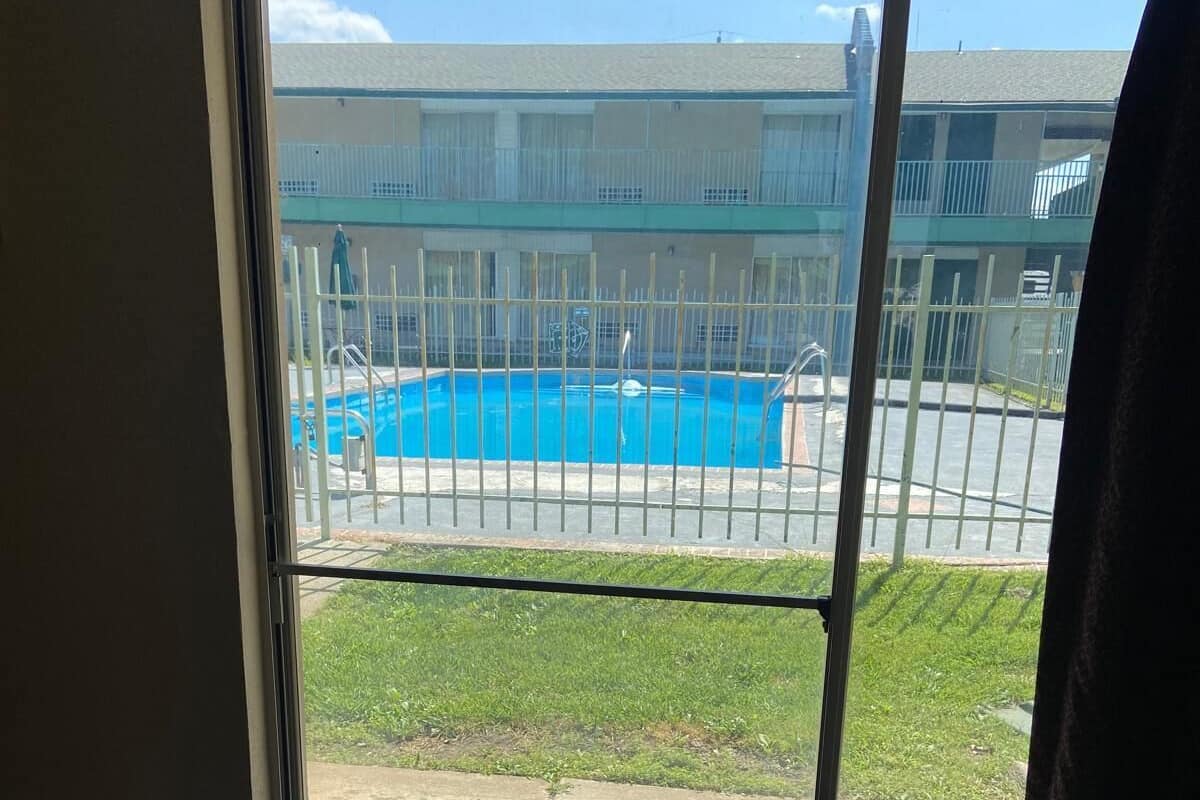 Una habitación con vista a una piscina a través de un ventanal.